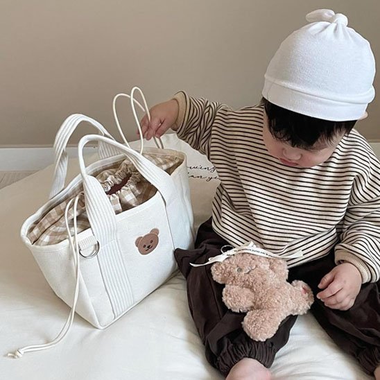 bebe assis avec sac a langer et nounours