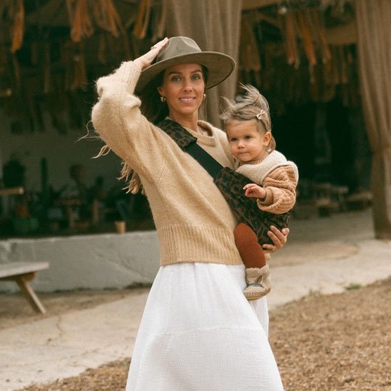 maman baladant bebe dans porte bebe leopard