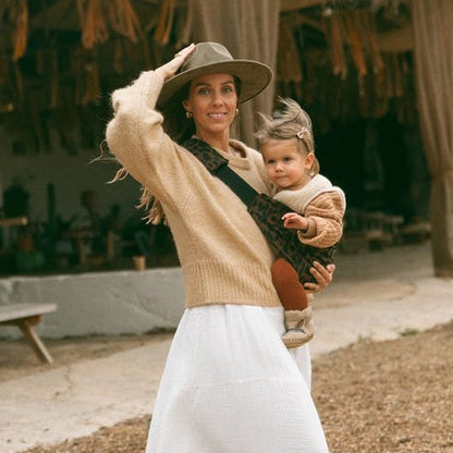 maman baladant bebe dans porte bebe leopard